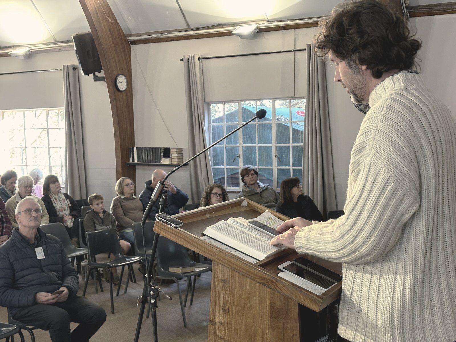 A member of the congregation reading the Bible aloud from the lectern