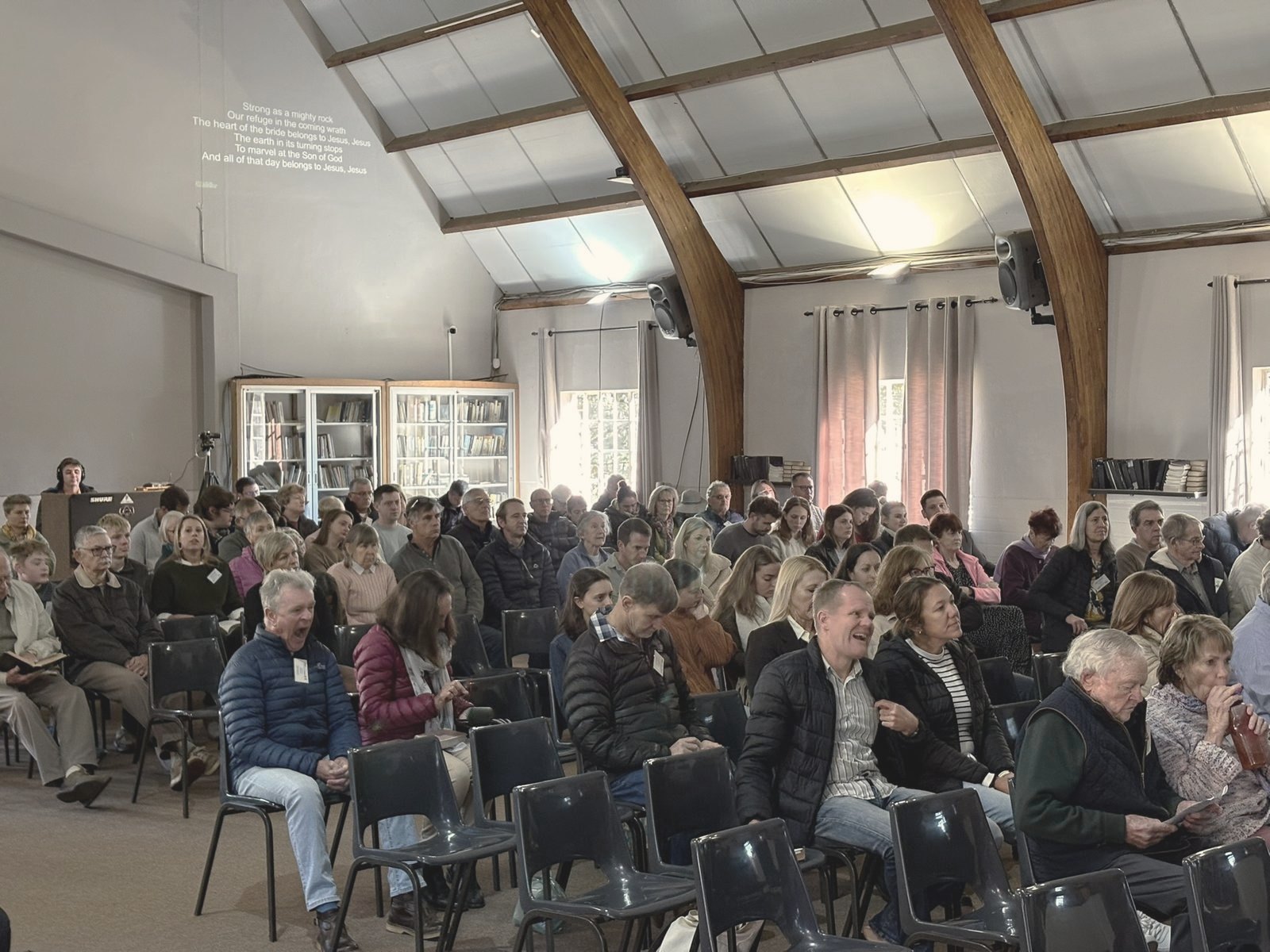 People seated and chatting before a Sunday service at Christ Church Hilton